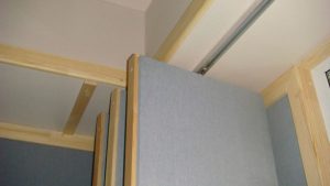Узел крепления подвесных акустических щитов, закрывающих оконный проём.
