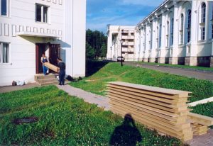 Два рабочих спокойно и весело заносят по две панели одновременно.